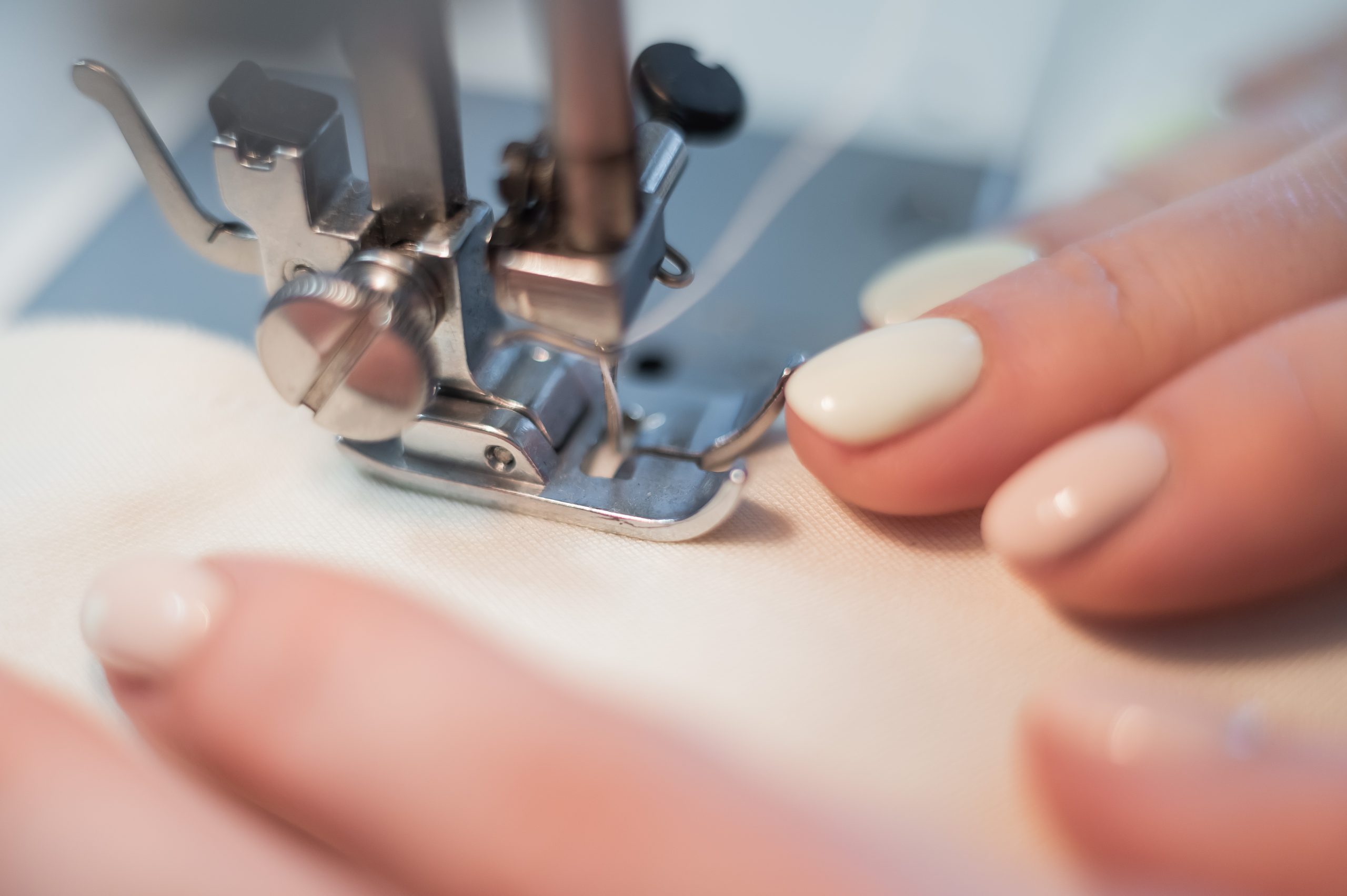 Close-up.,A,Woman,Works,On,An,Electric,Sewing,Machine,At